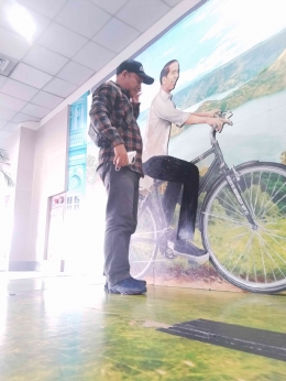 Gambar: penulis berfoto dengan Reflika bapak presiden Jokowi sedang naik sepeda, mencerminkan kesederhanaan dan pola hidup sehat.