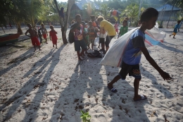 Sejumlah anak-anak bersama Kerry, guru Bahasa Inggris di sekolah mereka, memungut sampah anorganik di pesisir pantai Kampung Sawandarek, Pulau Mansuar, Distrik Meos Mansar, Kabupaten Raja Ampat. Papua Barat. Foto: Kompas/Riza Fathoni
