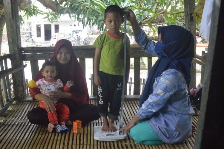Kader Posyandu mendatangi rumah warga untuk mengukur tinggi badan dan penimbangan berat badan kepada dua balita penderita stunting di Kabupaten Takalar, Sulawesi Selatan.| Kompas.com/Riza Salman