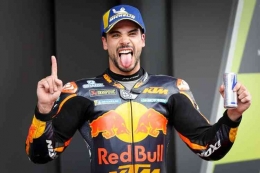 Oliveira menjulurkan lidah saat naik podium persis seperti Einstein. Sumber: MotoGP.com