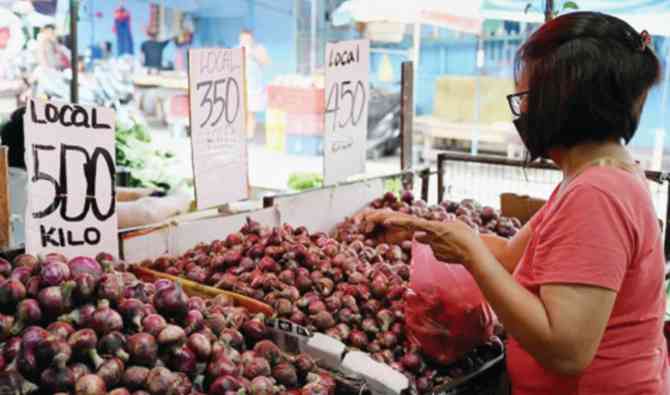 Seorang perempuan membeli bawang dengan harga selangit di pasar Manila pada Rabu (Foto, AFP)