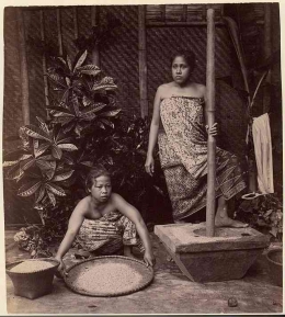 Dua perempuan Jawa tengah menumbuk padi (1860). Sumber: Wikimedia Commons