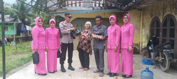 Kapolsek Lubuk Alung IPTU Arvi Yandri bersama Ketua Bhayangkari Ranting menyambangi korban banjir. (foto dok pribadi)