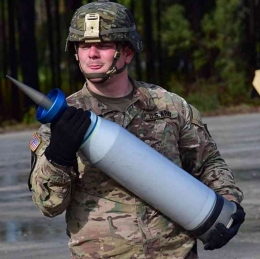 Seorang Prajurit Angkatan Darat AS membawa peluru APFSDS