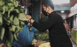 Seorang Pria Belanja di Pasar Menggunakan Tas Guna Ulang (Faqih Mauludin / Greeneration Foundation)