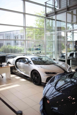 Photo by Dante Juhasz: https://www.pexels.com/photo/silver-bugatti-chiron-parked-in-front-of-glass-wall-12964186/ 
