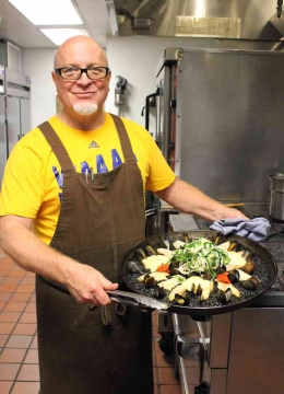 Seorang chef dengan squid-ink-paella yang siap disajikan. Sumber: www.duendeoakland.com