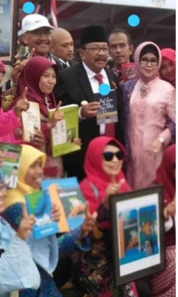 Penulis saat menyerahkan buku kepada Gubernur Jawa Timur saat itu Pak de Karwo ( Pegang Buku karya penulis) bersama ibu Nina Soekarwo di Lapangan Tugu Pahlawan 10 November 2018 ( foto: dok.pri)