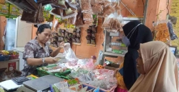 Seorang pedagang di pasar Sidodadi sedang melayani pembeli (24/12)
