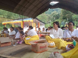 Rumpun keluarga yang duduk dalam tenda menggunakan seragam putih dan kuning sebagai simbol budaya syukuran. Sumber foto: Dok. Pribadi