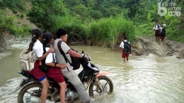 Guru Andik Santoso saat melalui medan yang berat ke tempatnya mengajar, yakni SDN Jipurapah 2, Kabupaten Lamongan. Sumber: beritajatim.com