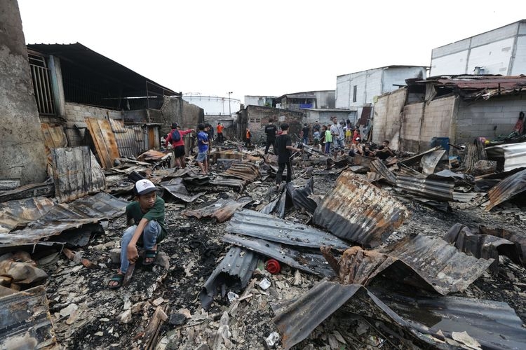 Warga melihat lokasi kebakaran di Kampung Tanah Merah usai ledakan Depo Pertamina Plumpang, Koja, Jakarta Utara, Sabtu (4/3/2023). Kebakaran ini mengakibatkan 17 orang meninggal dunia dan 51 orang luka-luka.(KOMPAS.com/KRISTIANTO PURNOMO) 