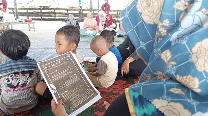 Gambar 2. Pembagian Brosur PMT Kepada Ibu Hamil dan Ibu Balita di Halaman Majelis Ta'alim As-Surur Desa Handil Barabai