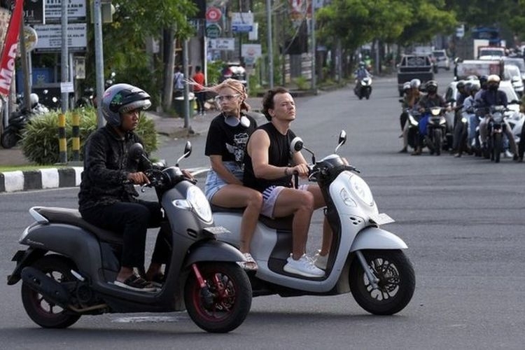 Sejumlah turis asing mengendarai sepeda motor tanpa mengenakan helm di Jalan Sunset Road, Kuta, Badung, Bali, Selasa (28/2/2023).(Antara Foto via KOMPAS.com) 