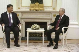 Tangkapan layar dari video yang menunjukkan Presiden China Xi Jinping (kiri) berbicara dengan Presiden Rusia Vladimir Putin (AP)