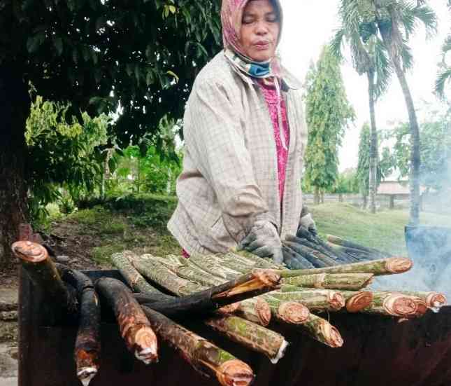 Seorang ibu sedang membakar pakkat. (Foto: sumutpos)