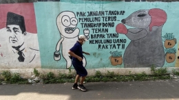 ilustrasi: Warga melintasi mural bergambar tikus yang menjadi simbol pelaku korupsi di kawasan Cipayung, Ciputat, Tangerang Selatan, Banten, Jumat (24/9/2020). (Foto: KOMPAS/WAWAN H PRABOWO)