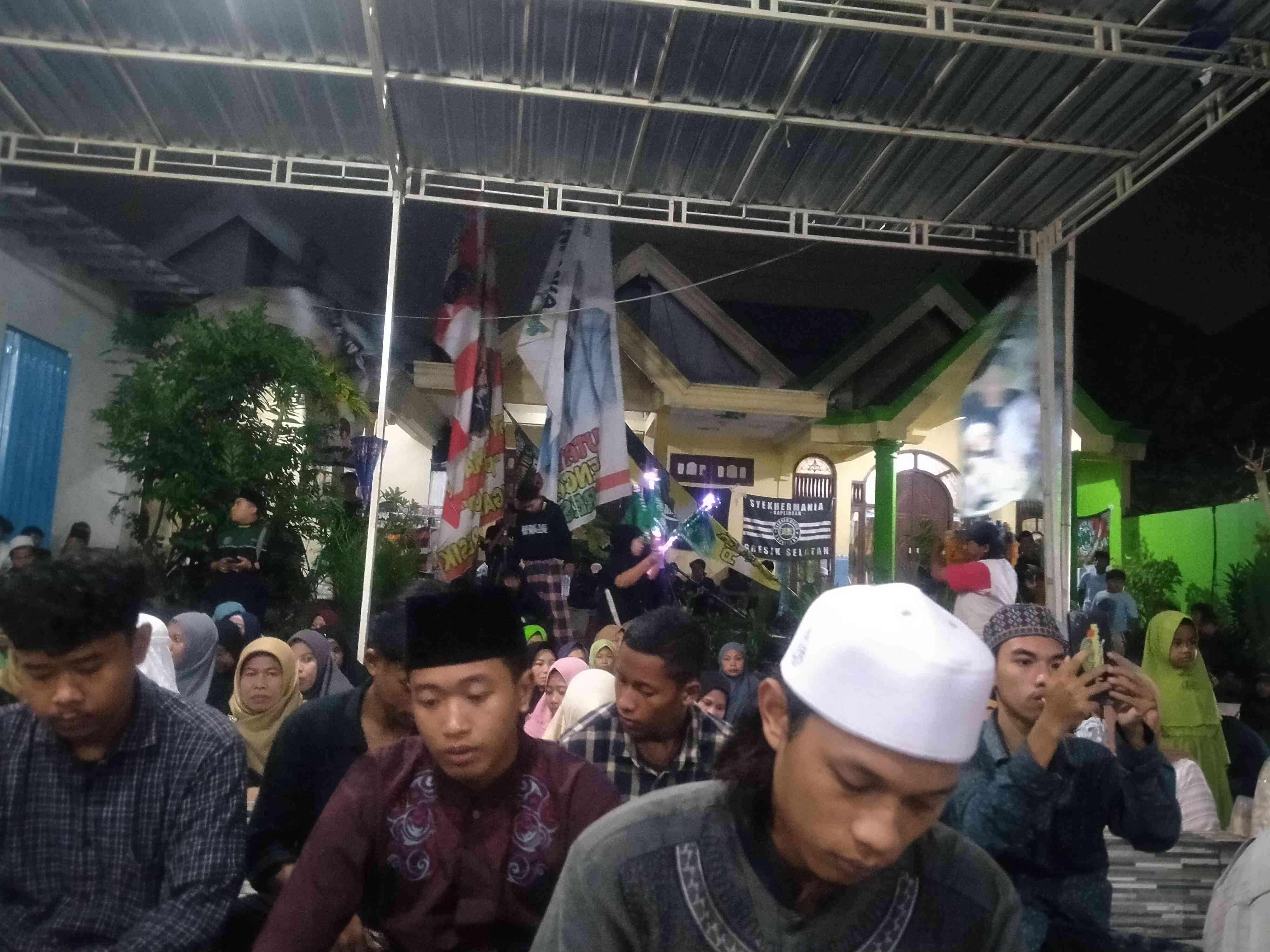 Para jamaah sedang mengikuti pembacaan sholawat nampak di belakang bendera sholawat berkibar (foto dokpri)