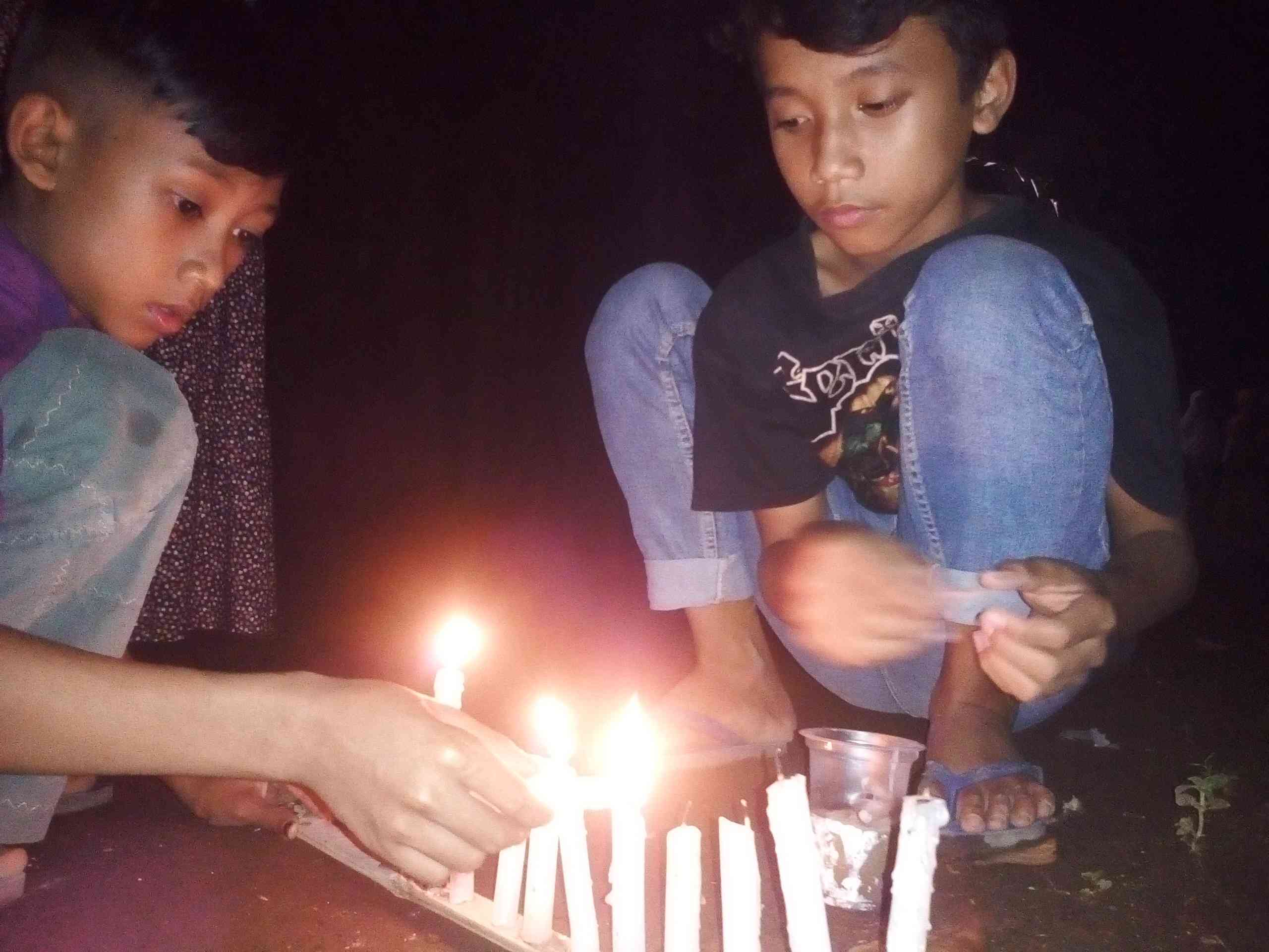 Anak-anak menghidupkan lilin. Foto; Sofiah