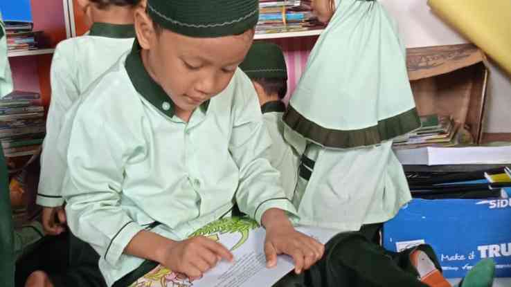 Ilustrasi anak PAUD membaca buku cerita bergambar di perpustakaan sekolah (Foto: Dokumentasi pribadi) 