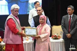 Gubernur Jammu dan Kashmir Manoj Sinha (kiri) sedang memberikan Penghargaan Konservasi Margasatwa kepada Aaliya Mir. | Sumber: wildlifesos.org