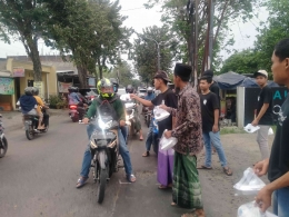 Pak RW (bersarung) ikut membantu membagikan takjil kepada pengguna jalan (foto dokpri)