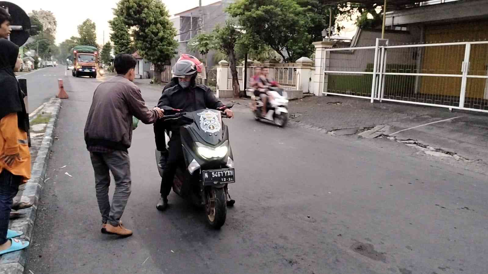 Salah Satu Sahabat Memberi Takjil Kepada Pengendara Motor yang Berhenti di Lampu Lalu Lintas (Izza Afkarina, Anggota Rayon FDKI Angkatan 2022)