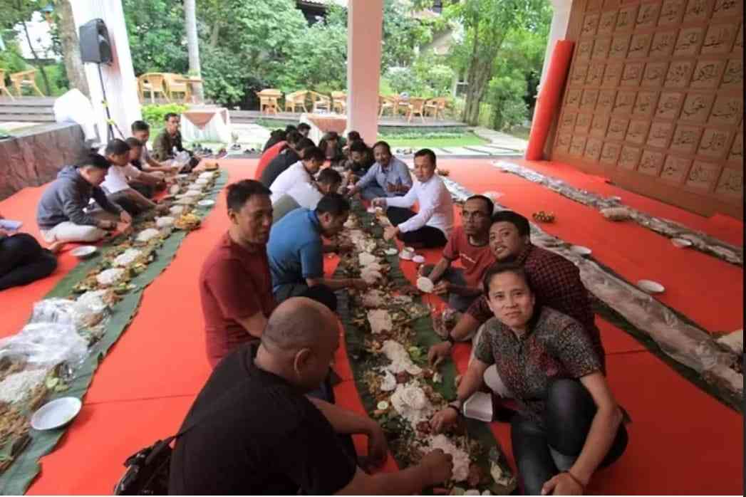 Duduk berhadap-hadapan dengan menu cucurak sudah siap santap di atas daun pisang (sumber foto: ayobogor.com)