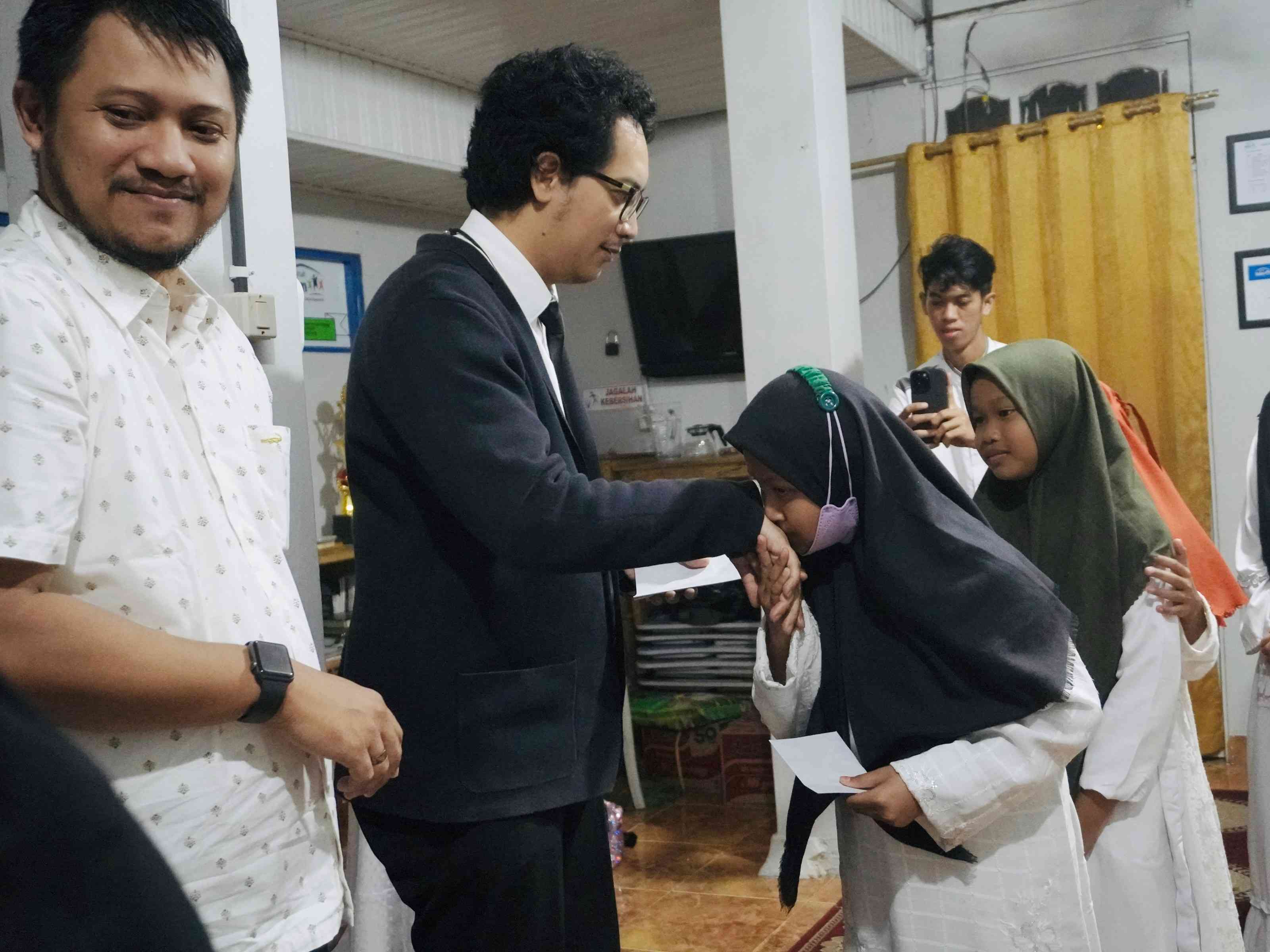 Memberikan salam tempel kepada anak-anak yatim. (sumber: dokumentasi pribadi)