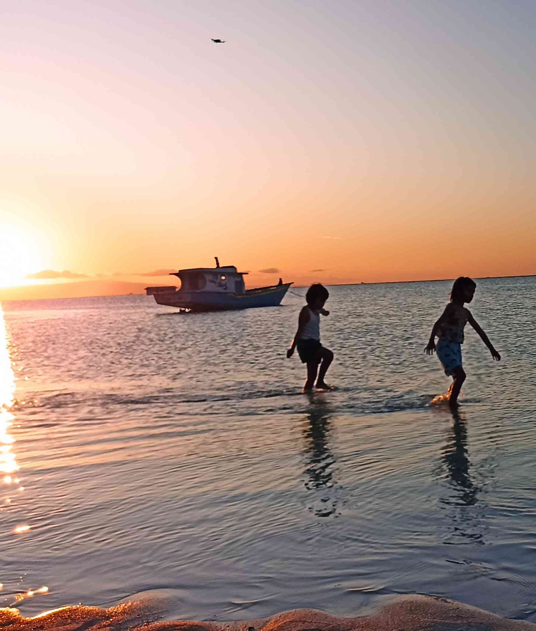 Anak-anak asyik bermain air sambil menikmati keindahan matahari terbenam di Pantai Walakiri (sumber gambar: dokumen pribadi) 