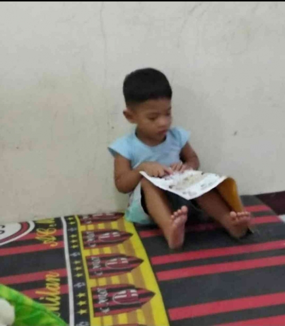 Omar saat usia 2 th membolak-balikkan buku cerita. Foto: Dokpri