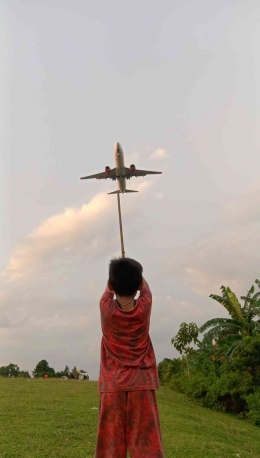 Gambar anak anak sedang bersantai ria menyaksikan pesawat terbang di lokasi sisi luar landasan pesawat, dokpri 