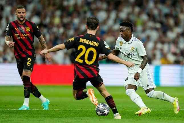 Vinicius Junior coba melewati Bernardo Silva di laga Real Madrid vs Manchester City, Liga Champions 2022-2023 (c) AP Photo/Jose Breton