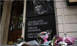 Bunga-bunga diletakkan di bawah sebuah papan foto di London untuk menghormati penyanyi legendaris Tina Turner. (Foto: Andy Rain/EPA/The Guardian)