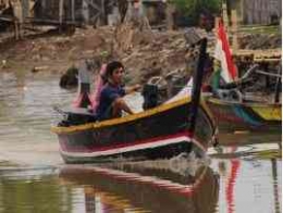 seorang Nelayan yang menyebrangi sungai Citarum pulang dari laut setelah mendapatkan hasil tangkapan selama seharian 