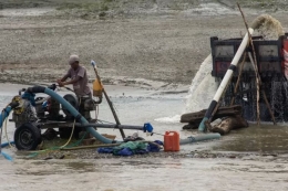 Pekerja menyedot pasir dari sungai ke atas truk menggunakan mesin di Sungai Palu, Sulawesi Tengah, Rabu (5/4/2023).(ANTARA FOTO via BBC INDONESIA)