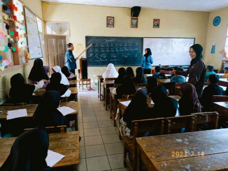 Mahasiswa sedang mengajar anak-anak SD Cikoneng Sumber Gambar: Kamera Pribadi