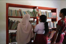 Siswa mencari buku bacaan di perpustakaan sekolah. (sumber: dokumentasi pribadi.)