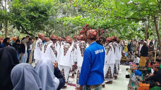 Berdiri sambil bergandengan tangan, para pelaku sandur khidmat melantunkan tembang. Dokumentasi pribadi
