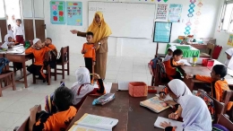 Maria Ulfa (31), guru honorer di SD Negeri 72 Banda Aceh, mengajar siswanya. Maria juga menjadi buruh cuci pakaian. (KOMPAS/ZULKARNAINI)