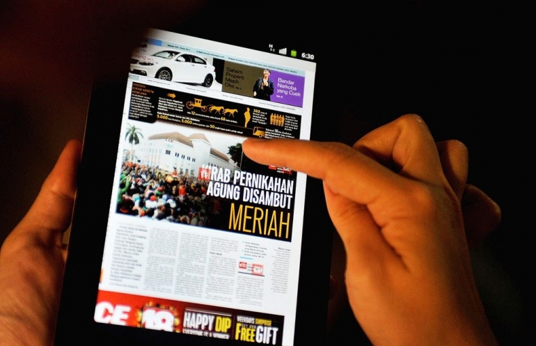 Ilustrasi membaca berita via media digital (Dok Kompas.id/Raditya Helabumi)