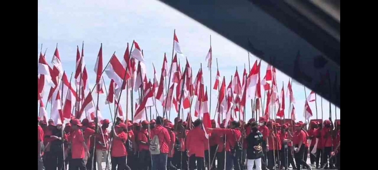 Sumber: Aibonme Keiya, Foto Mahasiswa Baru Universitas Satya Wiyata Mandala Nabire mengibarkan bendera Merah Putih dalam rangka mengikuti kegiatan PKK