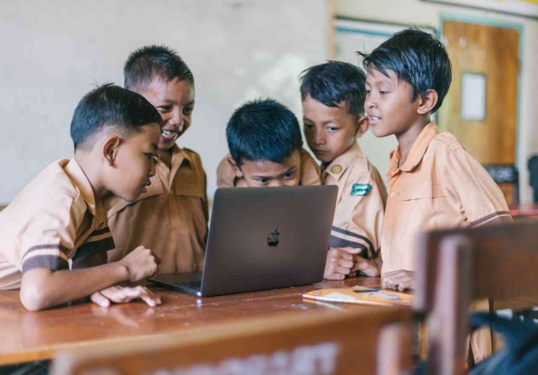 ilustrasi: siswa melihat macbook/laptop sebagai sarana belajar (dok. unsplas.com/Agung Pandit Wiguna)