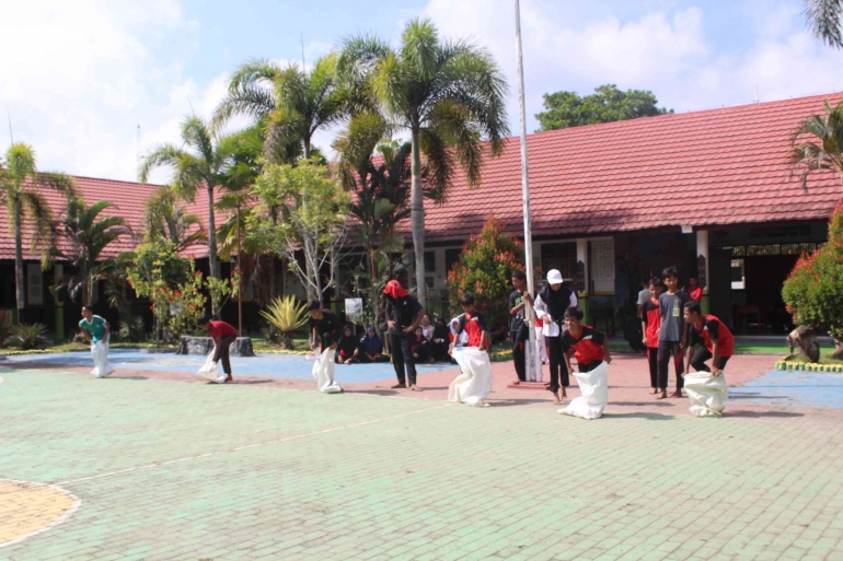 Foto ketika siswa-siswi mengikuti perlombaan balap karung di lapangan basket SMP Indah Makmur. Sumber : SMP Indah Makmur. 