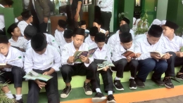 Di depan ruang kantor MTsN 6 Bantul, para siswa membaca buku cerita inspirasi (doc. pri)