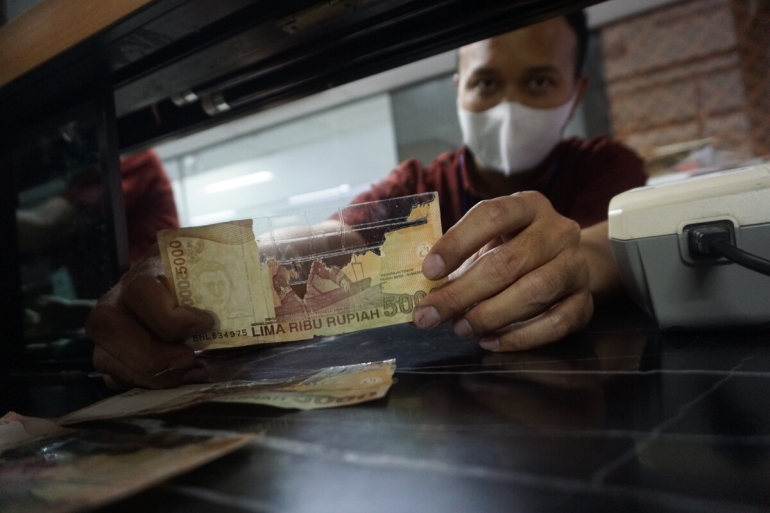 Petugas Bank Indonesia Kantor Perwakilan Purwokerto menunjukkan salah satu contoh uang mutilasi alias uang rusak di Purwokerto, Banyumas, Jawa Tengah, Kamis (7/9/2023). (KOMPAS/Wilibrordus Megandika Wicaksono)
