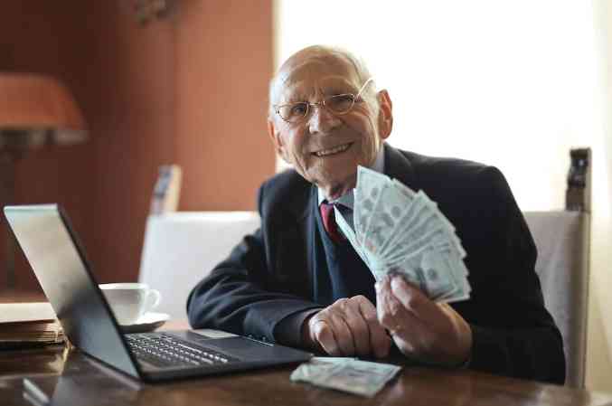 https://www.pexels.com/id-id/foto/pengusaha-senior-yang-bahagia-memegang-uang-di-tangan-saat-mengerjakan-laptop-di-meja-3823487/