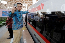 Seorang komuter selfie dekat tulisan WHOOSH sebelum peresmiannya 2 Oktober ybl oleh Presiden Jokowi. Foto :  bangkokpost.com dari Reuter