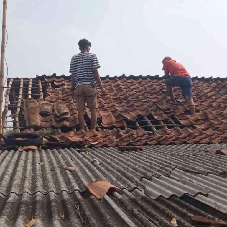 Terlihat warga yang tengah membetulkan atap rumah mereka yang berterbangan usai kejadian. Sumber gambar Mang Odo warga Cariu.
