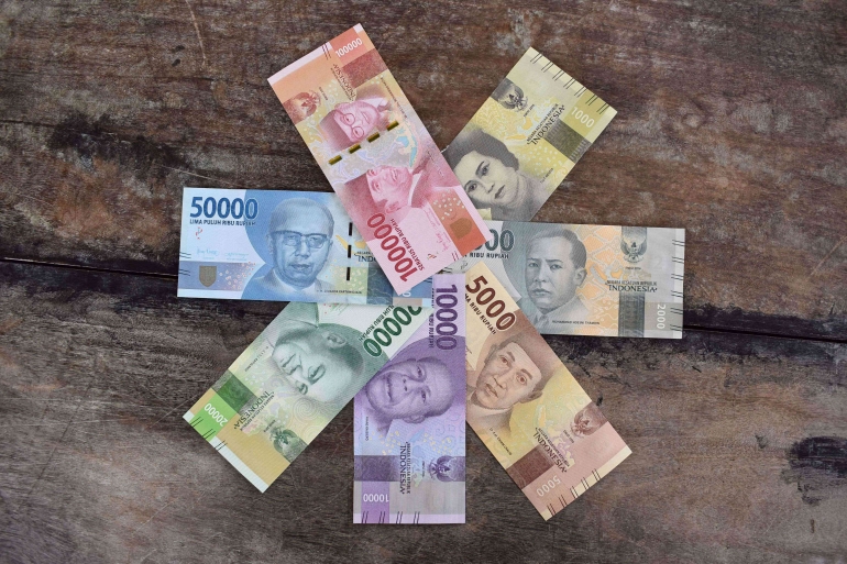 Sumber gambar: https://www.pexels.com/photo/banknotes-on-the-wooden-surface-10067197/